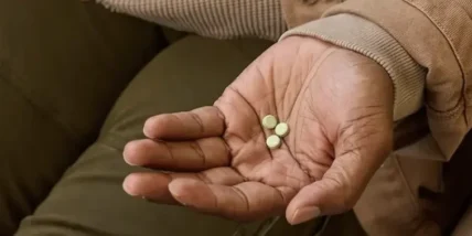 a man holding Found weight loss tablets in his hand